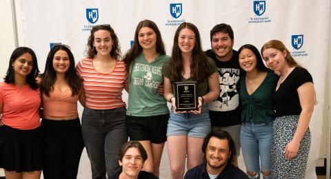 Student org holding up award plaque.